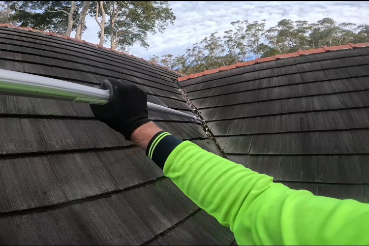 Professional gutter cleaning with extension poles, ensuring clean valleys on steep roofs in merimbula