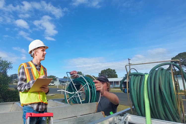 Hose management underway after merimbula gutter cleaner finishes rinsing gutters.
